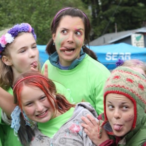 Girls on the Run coach making funny faces with three girls